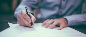 Man in formal dressing signs a contract