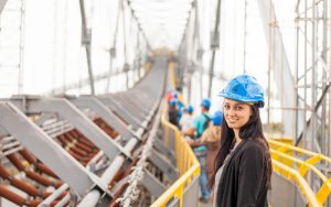 Female in hardhat smiles to the camera on a construction site