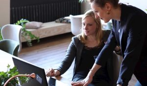 Boss and employee huddle around a computer