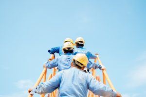 Workers in hardhats climb up outdoor staircase