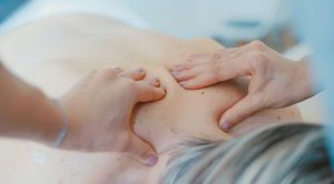 Women lying face down receives treatment on a sore neck