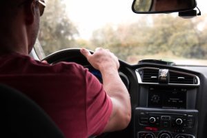 Man drives car down rural road